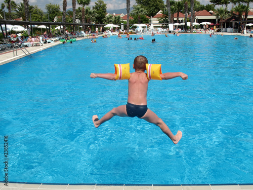 boy jumping in swimming pool