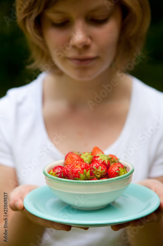 Girl holding a bowl of strawberries