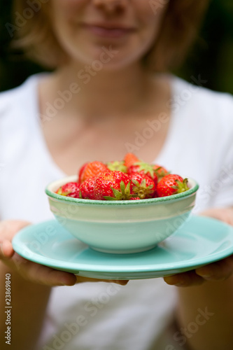 Girl holding a bowl of strawberries