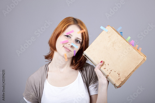 Foto Red-haired businesswoman with book and notes on face.
