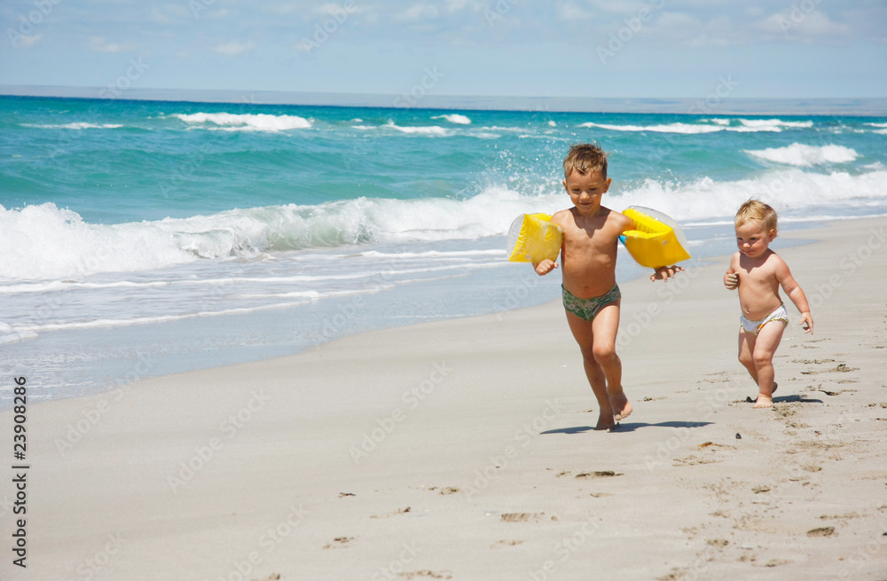 Naklejka premium two kids running on beach