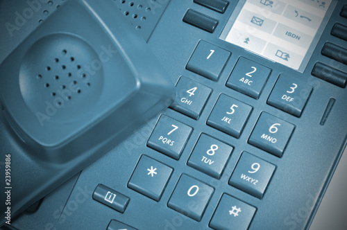 Blue concept of the office telephone with picked up receiver.