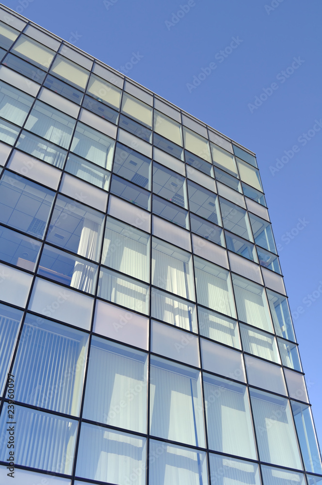 Facade of a modern office building made from blue glass.