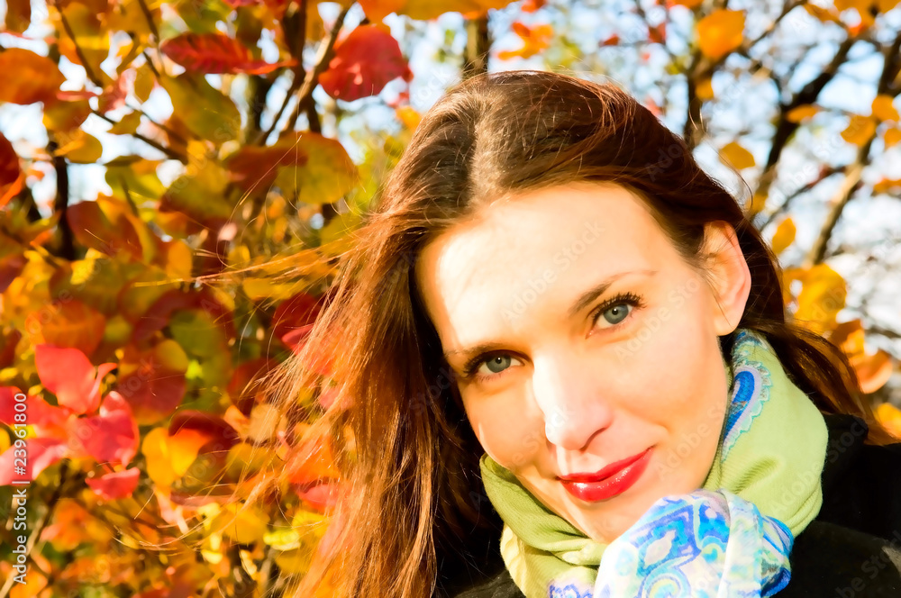 portrait of young smiling woman in autumn park