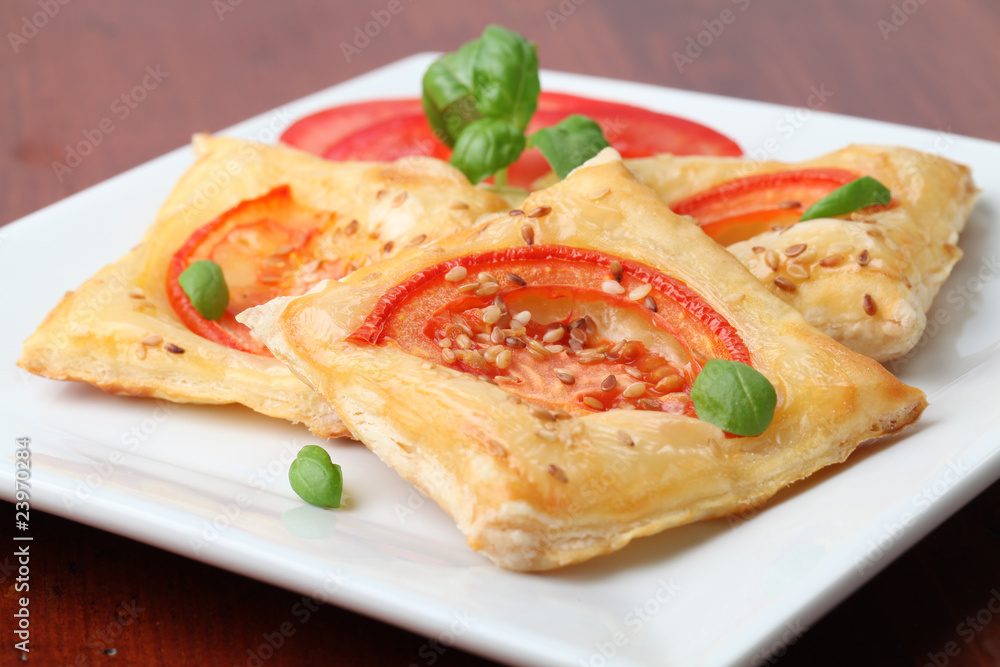 Puff pastry with cheese and tomatoes seasoned with sesame seeds Puff pastry with cheese and tomatoes seasoned with sesame seeds