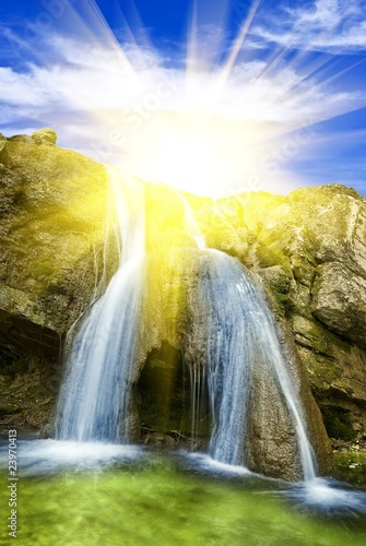 sparkle sun above a waterfall