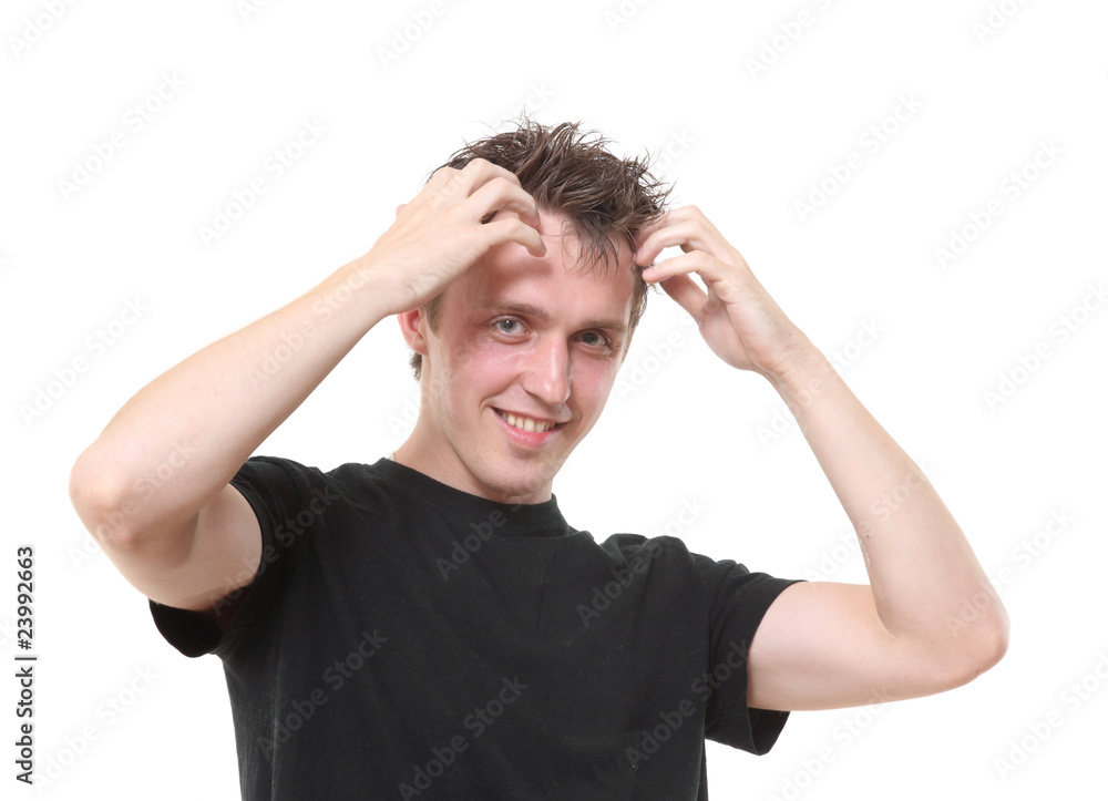 The young man holds hands at a head and smiles The young man holds hands at a head and smiles