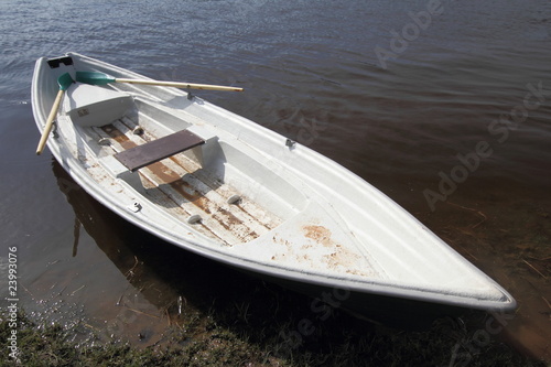 Boat with oar on water beside coast