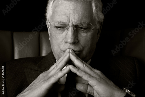 old businessman seated on a chair, thinking