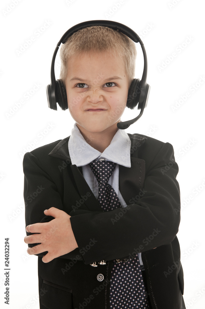 A small boy wearing a headset and looking angry. A small boy wearing a headset and looking angry.