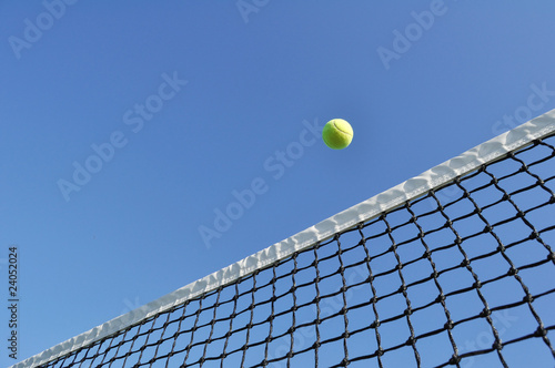 Yellow Tennis Ball Flying Over the Net