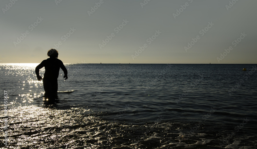 Silhouette of man running in sea