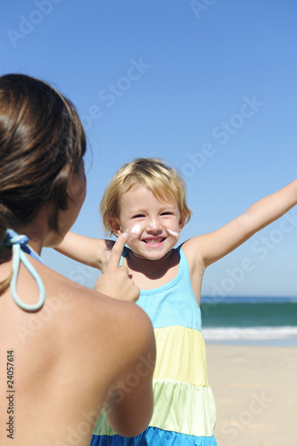 Mother applying suncream to her happy child