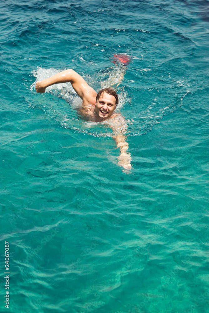 happy smiling man swimming in turquoise sea