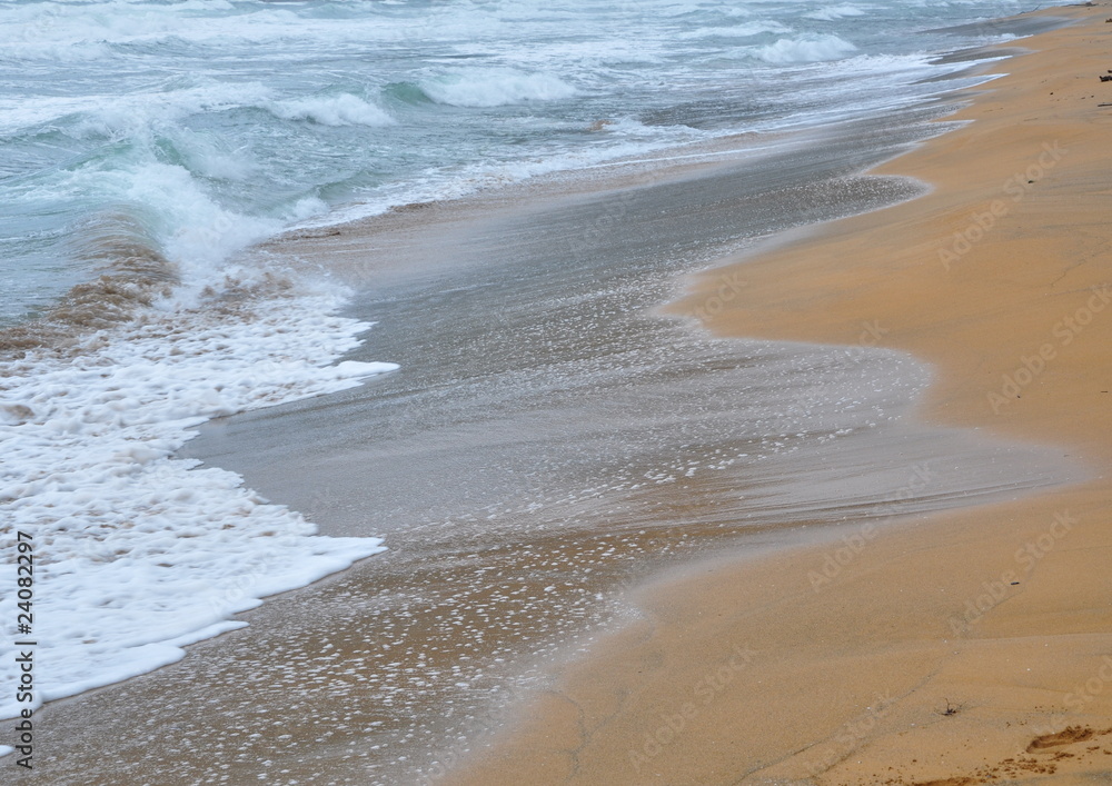 écume sur le sable doré d'une plage