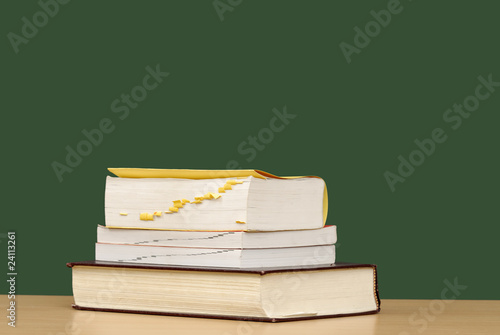 pile de livre en face d'un tableau d'école