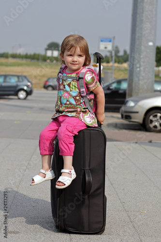 Kind auf Koffer am Flughafen auf Reise