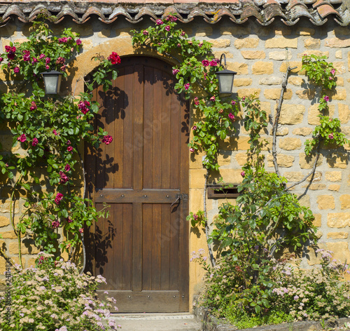 A wooden front door in the ancient stone house