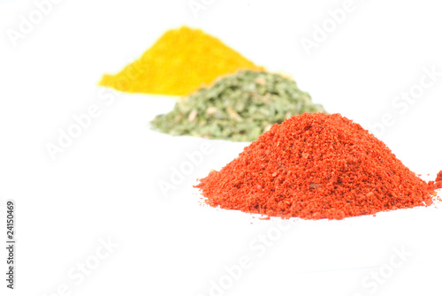 Heaps of various ground spices on white background