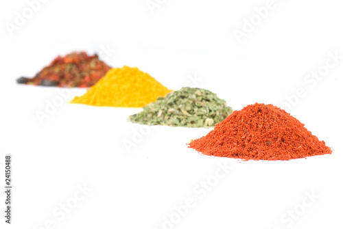 Heaps of various ground spices on white background