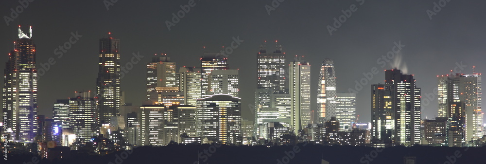 Naklejka premium Tokio nocą panorama z oświetlonymi wieżowcami