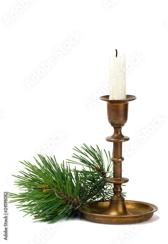 Candlestick with candle and pine branch on white background