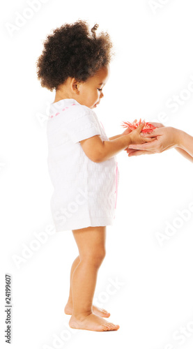 Pretty little girl taking a flower from woman's hands