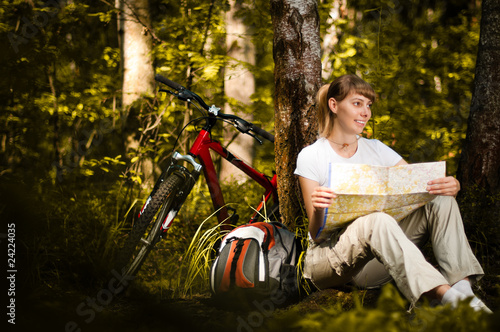 young woman with bicycle in forest