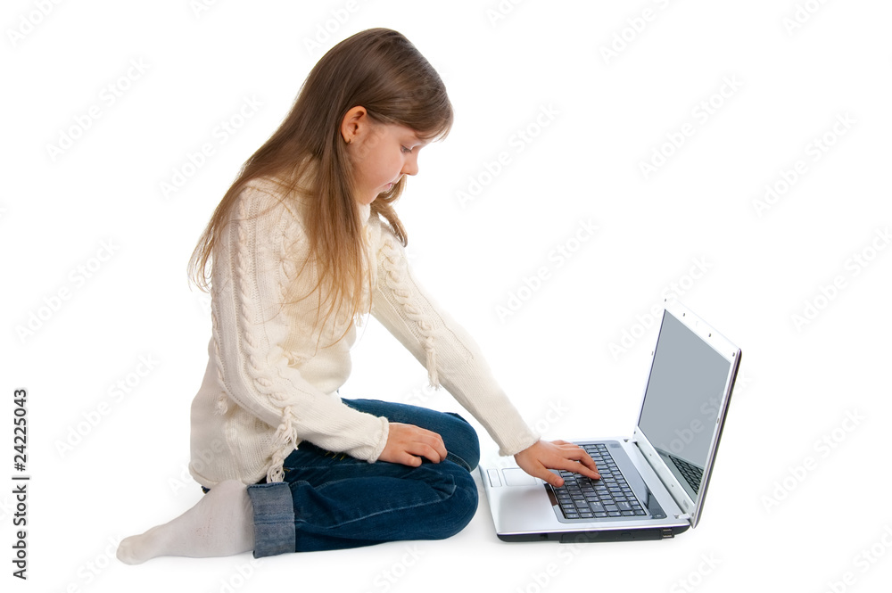 Fototapeta premium The sitting little girl with the laptop