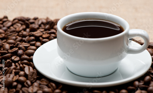 Cup of coffee on coffee grains © Olga Galushko
