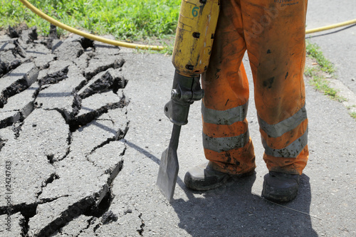 Worker  at site working with pneumatic plugger hammer photo