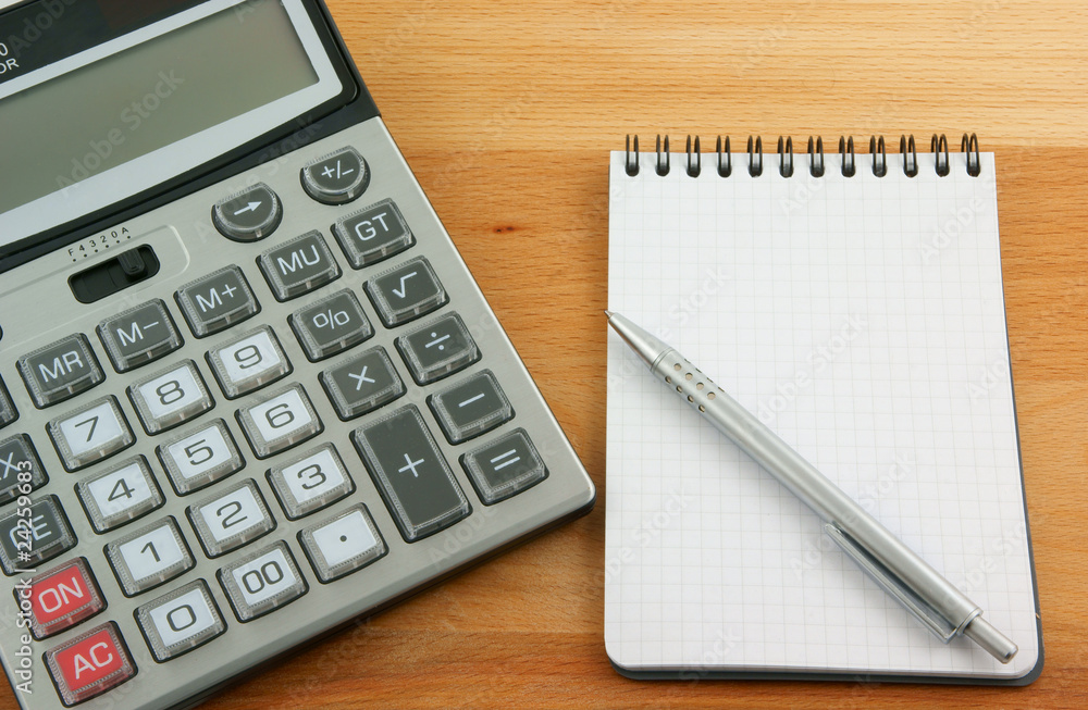 Calculator, pen and notebooks on wooden table Calculator, pen and notebooks on wooden table