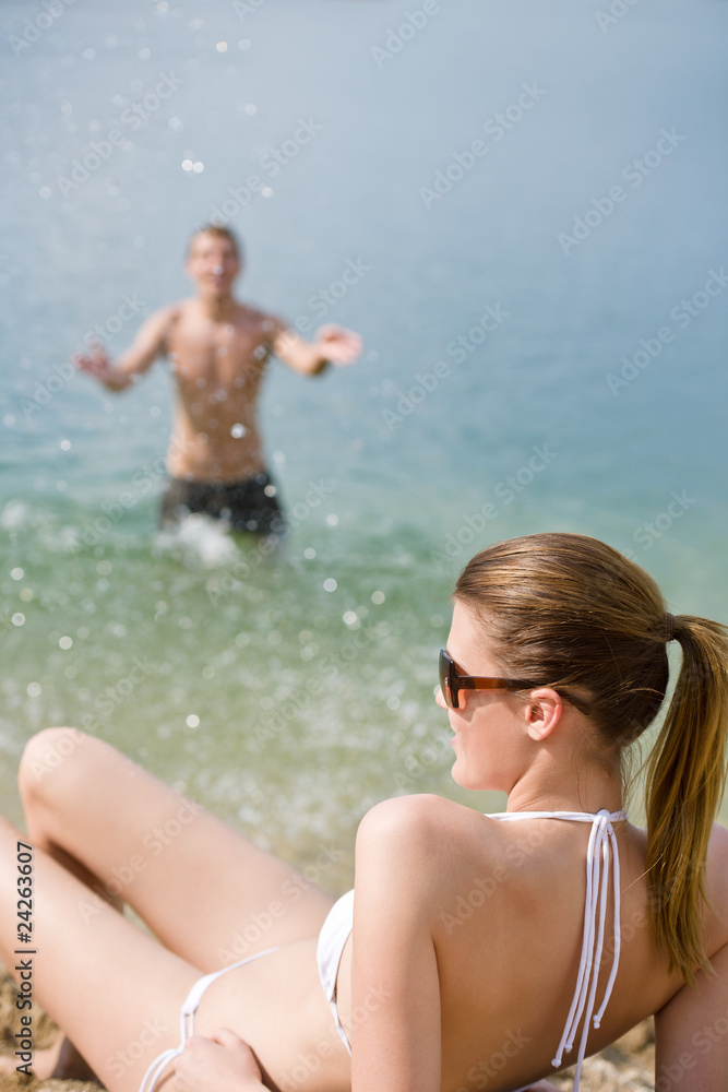 Woman in bikini sunbathing by sea on beach Woman in bikini sunbathing by sea on beach