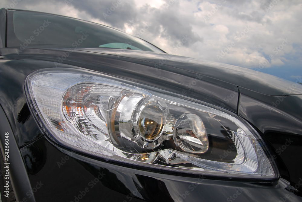 modern european car headlight against stormy sky