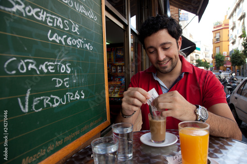 Hombre joven desayunando en Sevilla photo