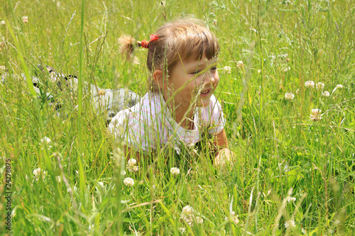 four years old girl lies in the grass