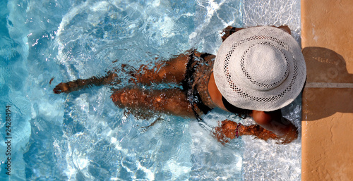 Konstfotografi Jeune femme se relaxant au bord de sa piscine