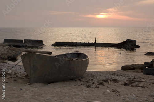 Fishing boat on a seashore at the sunset