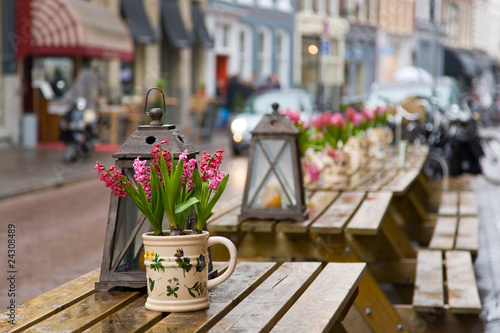 Cafe table with flowers and lantern. Focus on flowers