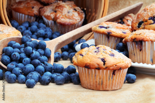 Fresh Blueberry Muffin with raw blueberries spilling from a wooden spoon in the background Fototapet