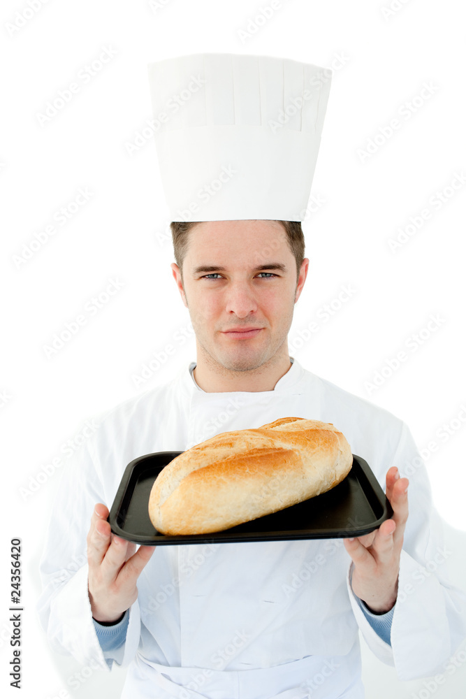 A male cook holding bread looking at the camera against white A male cook holding bread looking at the camera against white