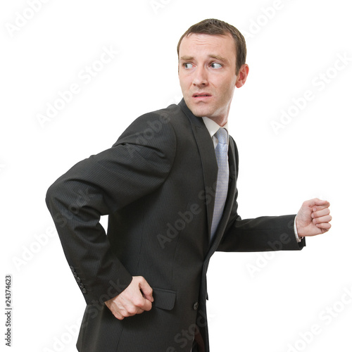 stressed businessman running away looking back