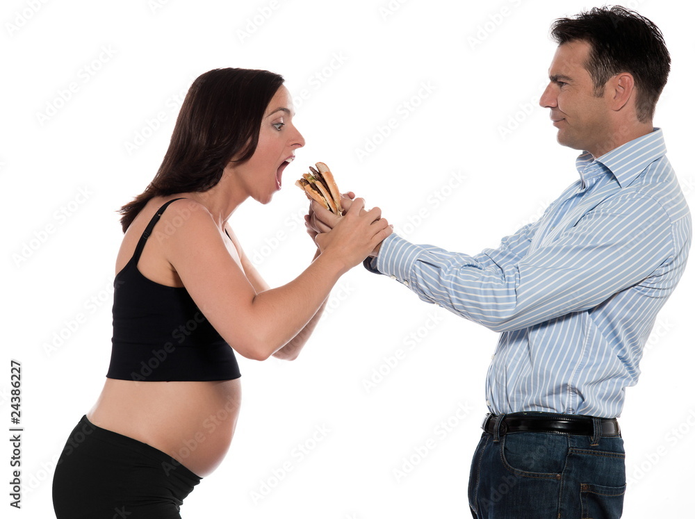 Couple expecting baby eating hamburger Couple expecting baby eating hamburger