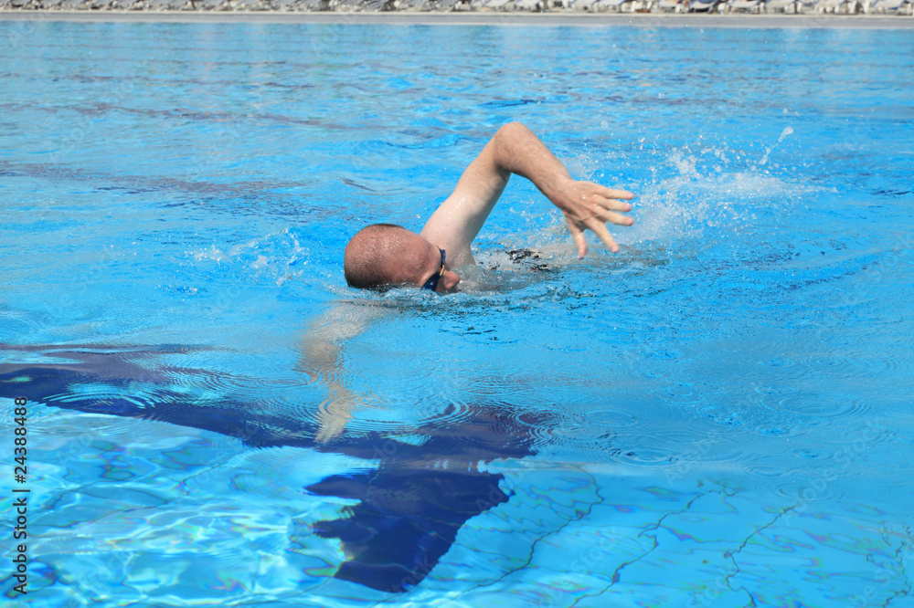 Young man swimming free style