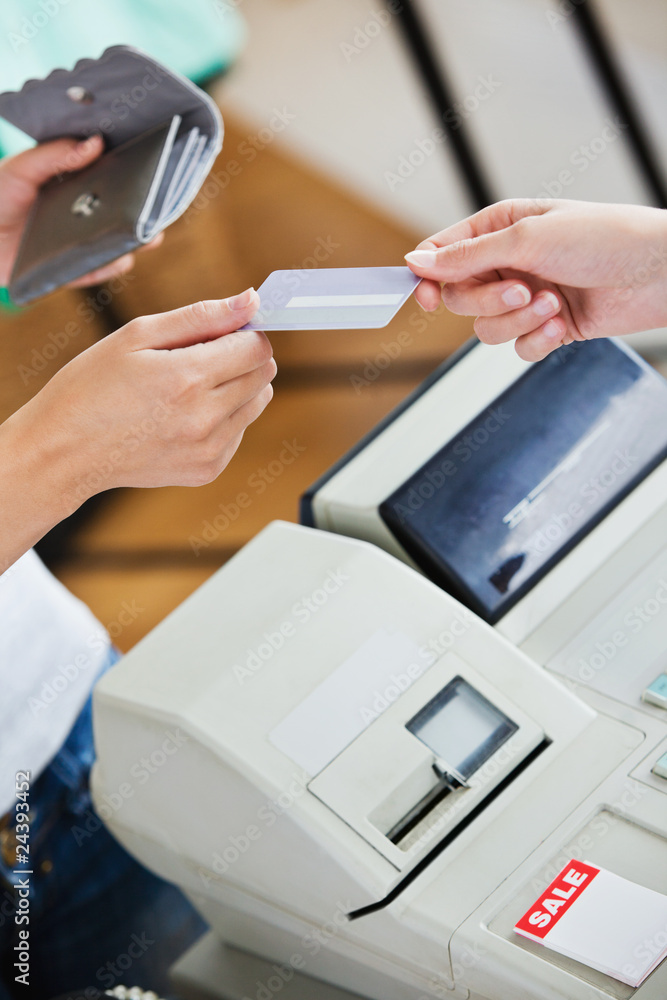 Close-up of a teen woman paying with her credit card Close-up of a teen woman paying with her credit card