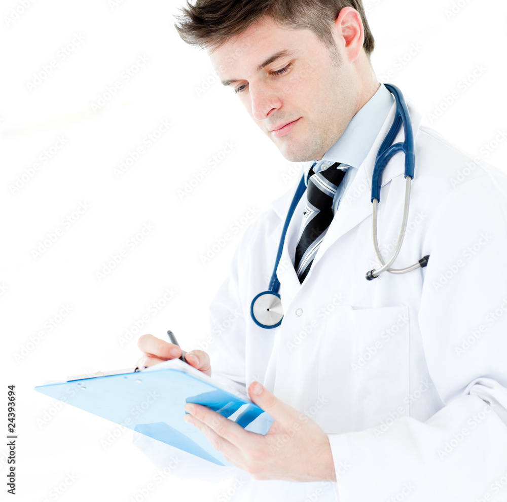 Serious male doctor writing on a clipboard Serious male doctor writing on a clipboard