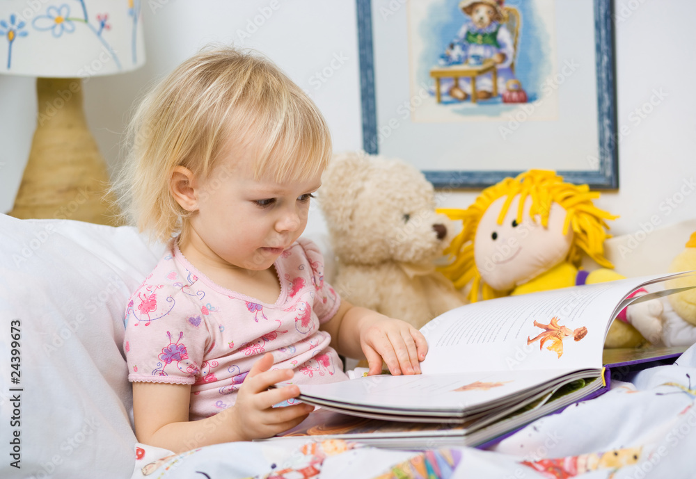 little girl in bed reading book - obrazy, fototapety, plakaty 