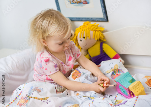 little girl in bed with toys