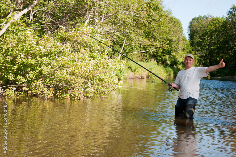 A fisherman fishing on a river