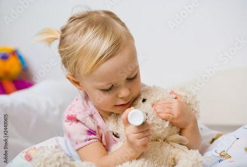 Photos little girl in bed playing with teddy bear